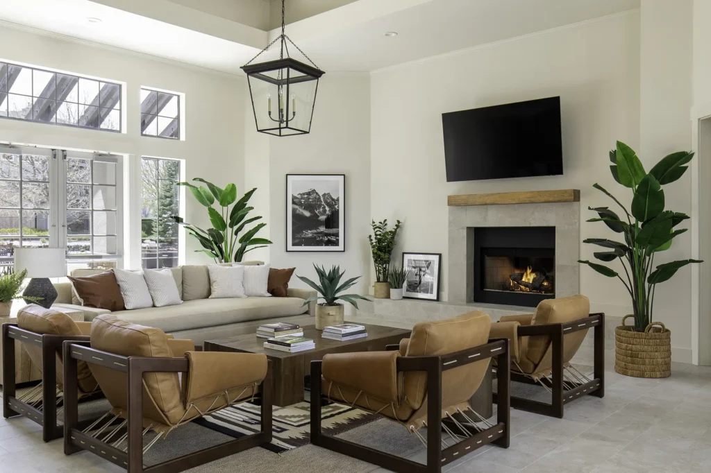 Community lounge with sofas and chairs around a fireplace and TV